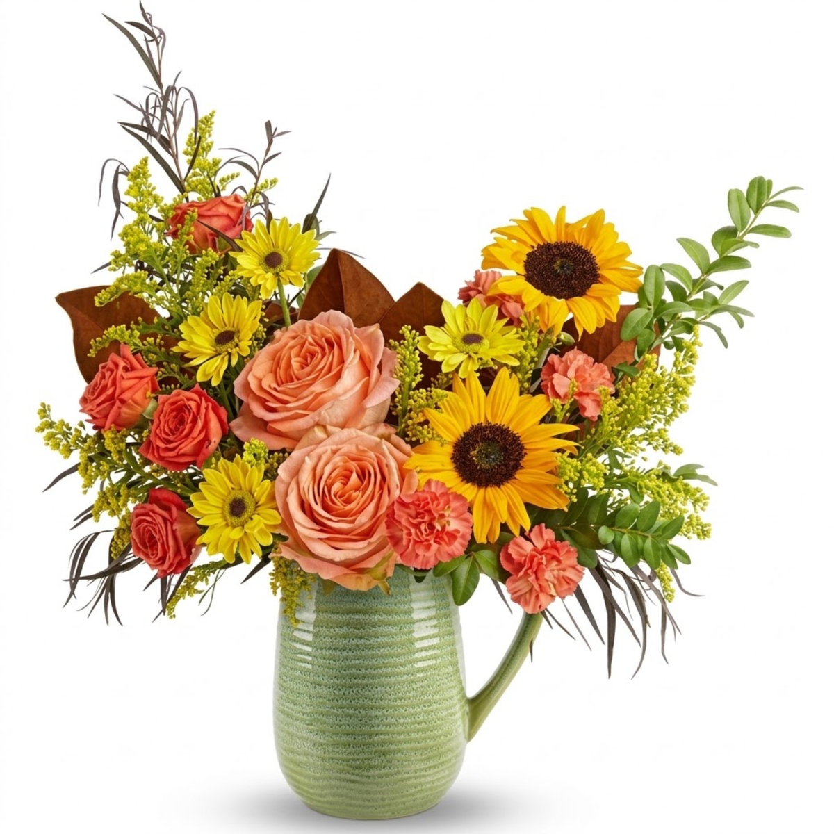 A vibrant floral arrangement featuring yellow sunflowers, coral roses, yellow daisies, and green foliage in a textured light green ceramic pitcher vase, set against a solid white background.