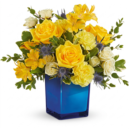 Golden blue bouquet with yellow roses, alstroemeria and blue thistle in cobalt blue glass vase
