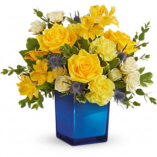 Golden blue bouquet with yellow roses, alstroemeria and blue thistle in cobalt blue glass vase
