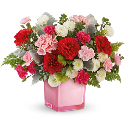 Pink tranquil love bouquet with red and pink carnations, white button mums in pink glass cube vase