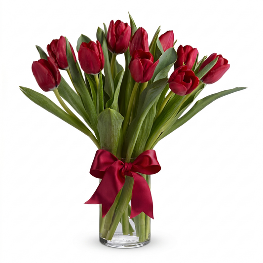 Radiantly red tulips bouquet in clear glass cylinder vase with red satin ribbon bow