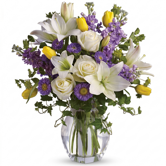 Spring waltz bouquet with white roses, asiatic lilies, purple asters, yellow tulips and lavender stock in clear glass vase