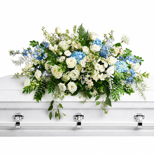 White rose and blue hydrangea casket spray with delphinium